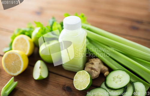 Image of close up of bottle with green juice and vegetables