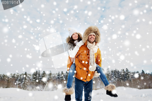 Image of happy couple having fun over winter background