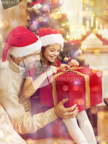 Image of smiling father and daughter opening gift box