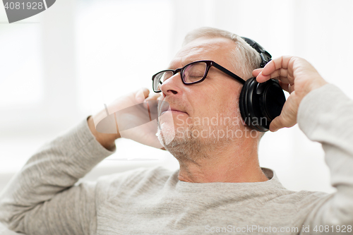 Image of happy man in headphones listening to music at home