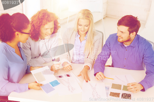 Image of smiling creative team looking at sketch