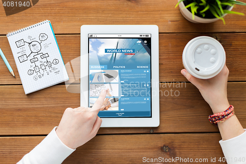 Image of close up of woman with tablet pc on wooden table