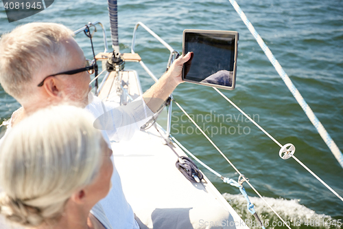 Image of senior couple with tablet pc on sail boat or yacht