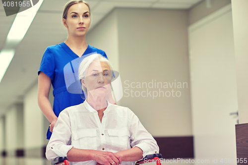 Image of nurse with senior woman in wheelchair at hospital