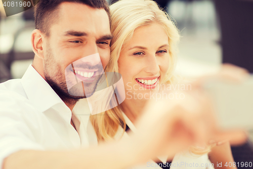 Image of happy couple taking selfie with smatphone outdoors