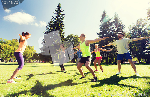 Image of group of happy friends exercising outdoors