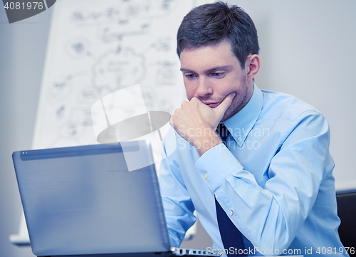 Image of businessman sitting with laptop in office