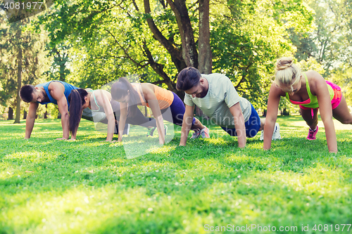 Image of group of friends or sportsmen exercising outdoors