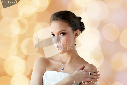 Image of beautiful woman with jewelry over holidays lights