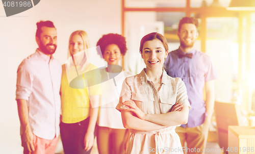 Image of happy young woman over creative team in office