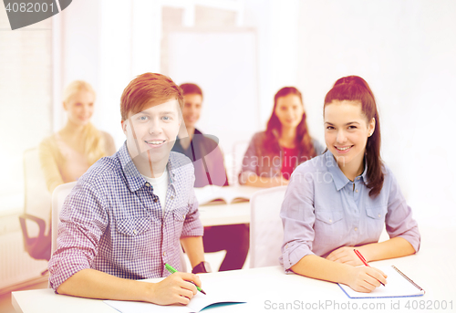 Image of smiling students with notebooks at school