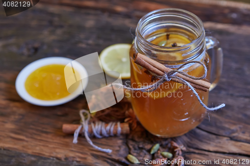 Image of Tea with lemon and honey on the wooden background.