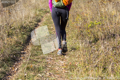 Image of Young woman walking by hiking trail