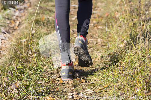 Image of Young woman walking by hiking trail