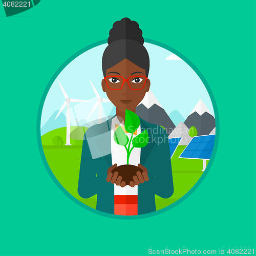 Image of Woman holding green small plant.