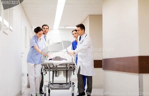 Image of medics with woman on hospital gurney at emergency