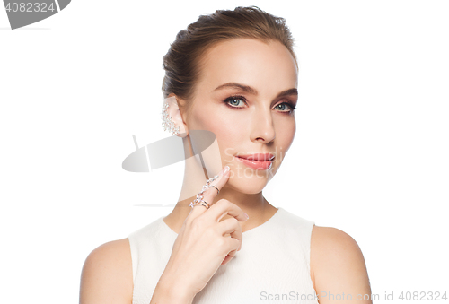 Image of smiling woman in white dress with diamond jewelry