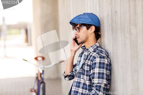 Image of man with smartphone and fixed gear bike on street