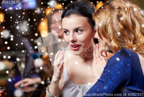 Image of happy women gossiping at night club over snow