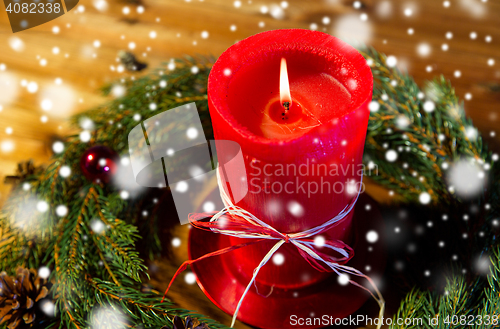 Image of fir branch wreath with candle on wooden table