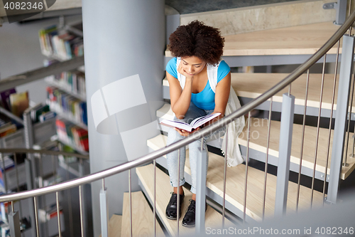 Image of african student girl reading book at library