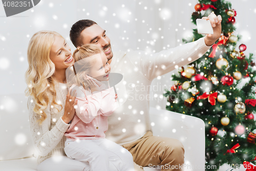 Image of family taking selfie with smartphone at christmas