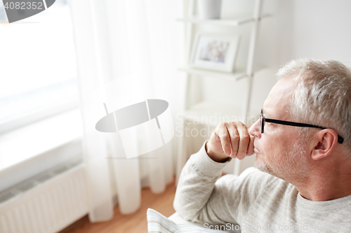 Image of close up of senior man in glasses thinking