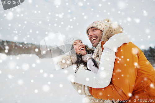 Image of happy couple hugging outdoors in winter
