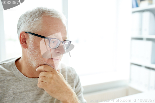 Image of close up of senior man in glasses thinking