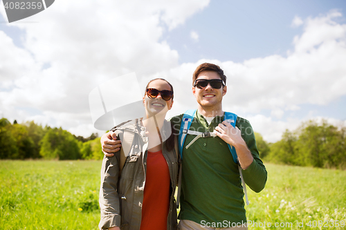 Image of happy couple with backpacks hiking outdoors