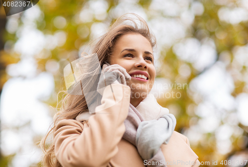 Image of woman calling on smartphone in autumn park