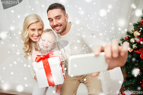 Image of family taking selfie with smartphone at christmas