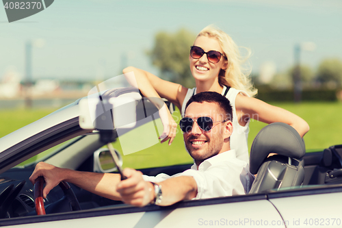 Image of happy couple in car taking selfie with smartphone