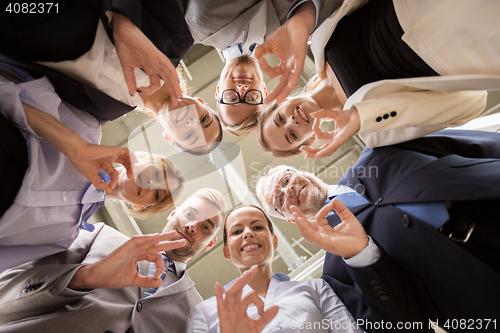 Image of business people showing ok hand sign at office