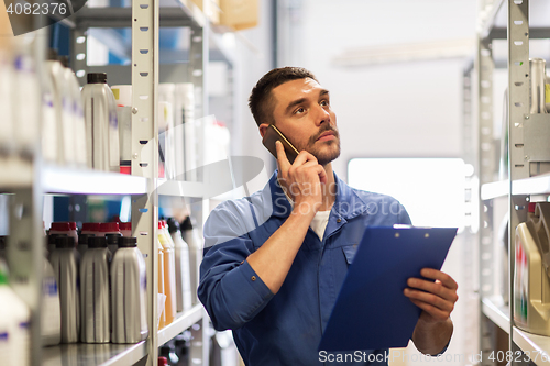 Image of auto mechanic with clipboard at car workshop