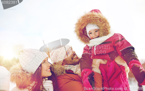 Image of happy family with child in winter clothes outdoors
