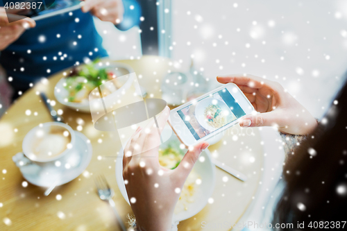 Image of close up of couple picturing food by smartphone