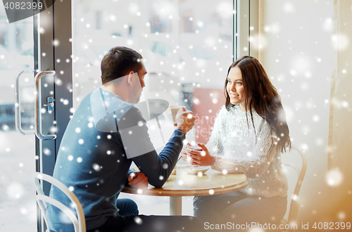 Image of happy couple drinking tea and coffee at cafe