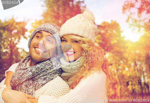 Image of happy couple in warm clothes over autumn