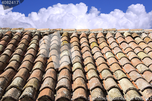 Image of Old roof tiles, blue sky and clouds in the background