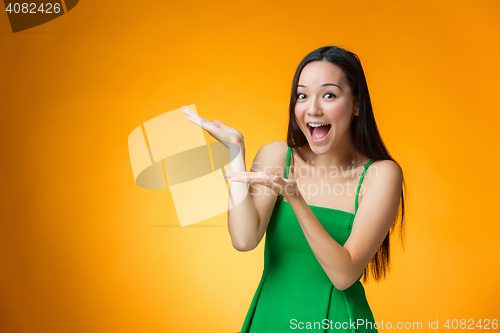 Image of The happy Chinese girl on yellow background