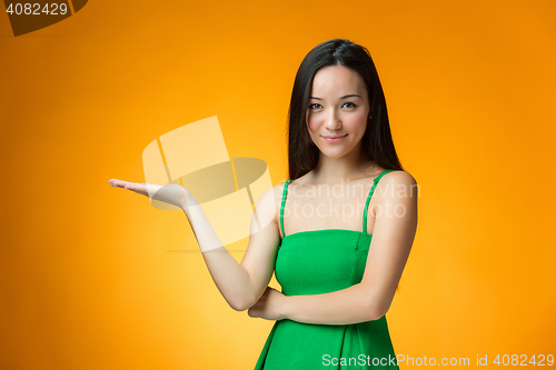 Image of The happy Chinese girl on yellow background