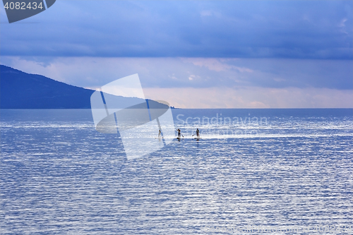 Image of Young people Paddling Together in the sea