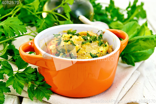 Image of Fish baked with tomato in red pot on board