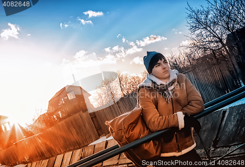 Image of Tourist In The Village Against The  Rays Of The Setting Sun