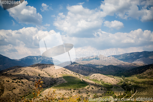 Image of Panoramic scenic views of hilly valley and blue cloudy sky