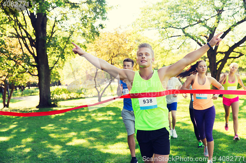 Image of happy young male runner winning on race finish
