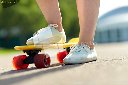 Image of close up of female feet riding short skateboard