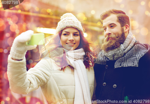 Image of couple taking selfie with smartphone in old town