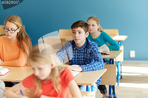 Image of group of students with notebooks at school lesson